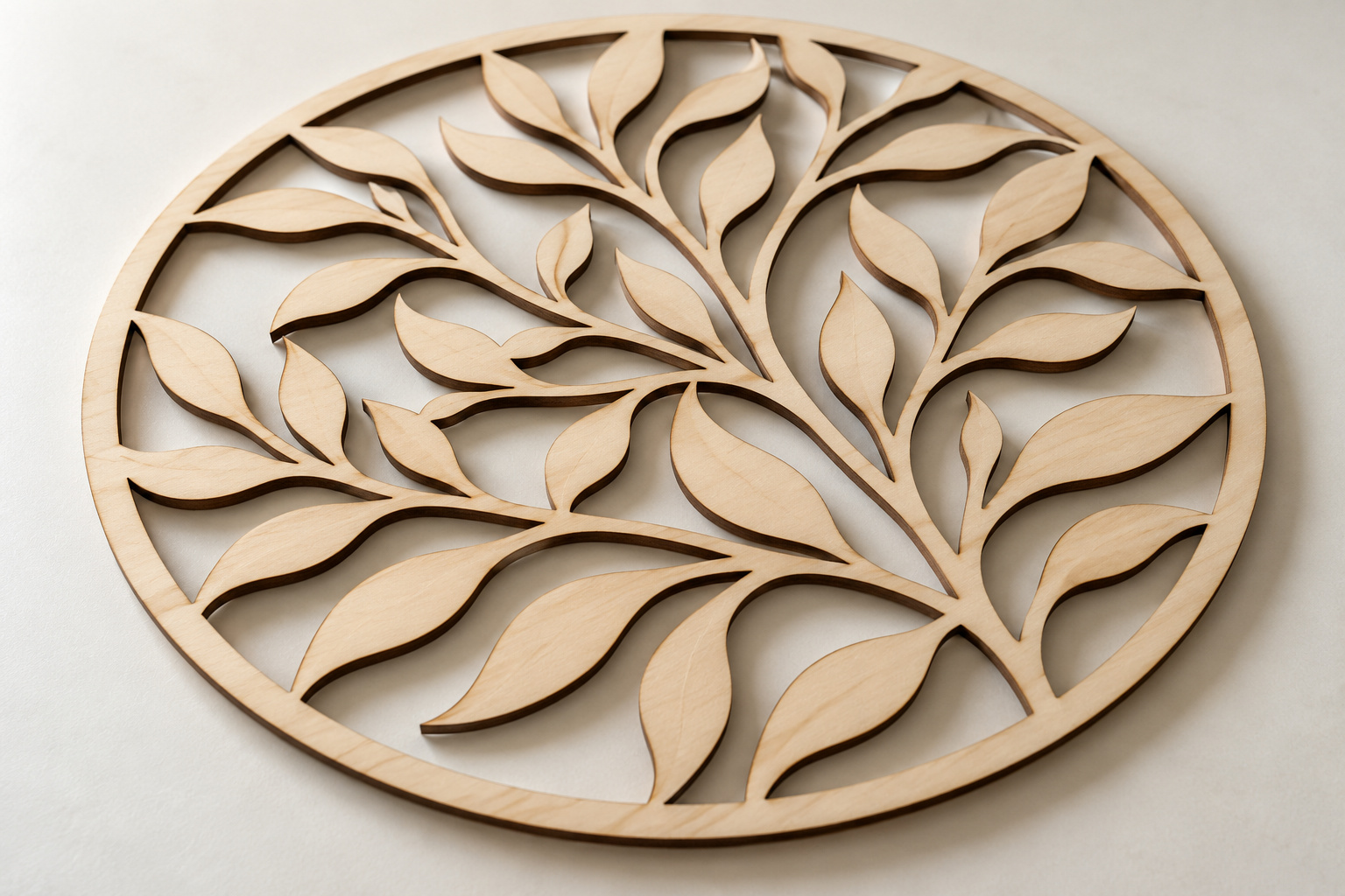 Circular plywood decoration with a laser-cut botanical pattern and openwork details.