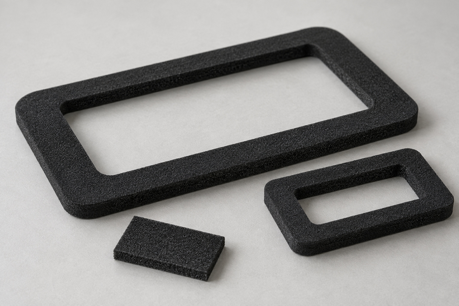 Rectangular black foam gasket frames with rounded corners and visible sheet thickness.