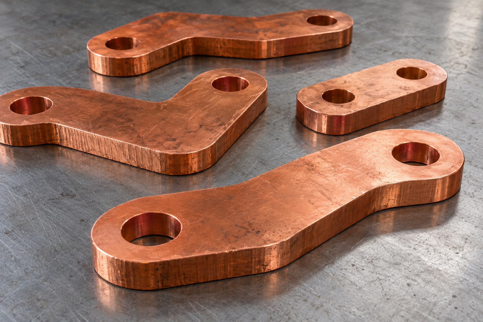Copper busbar blanks with mounting holes arranged on a workshop bench